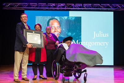 Julius Montgomery receiving his doctorate plaque