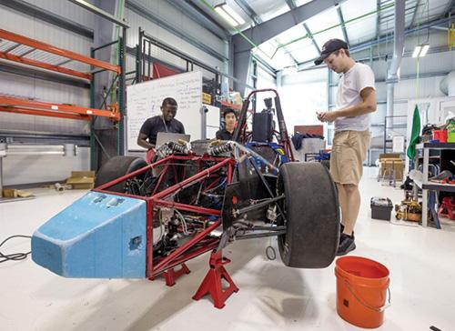 Florida Tech students working on a project involving a car