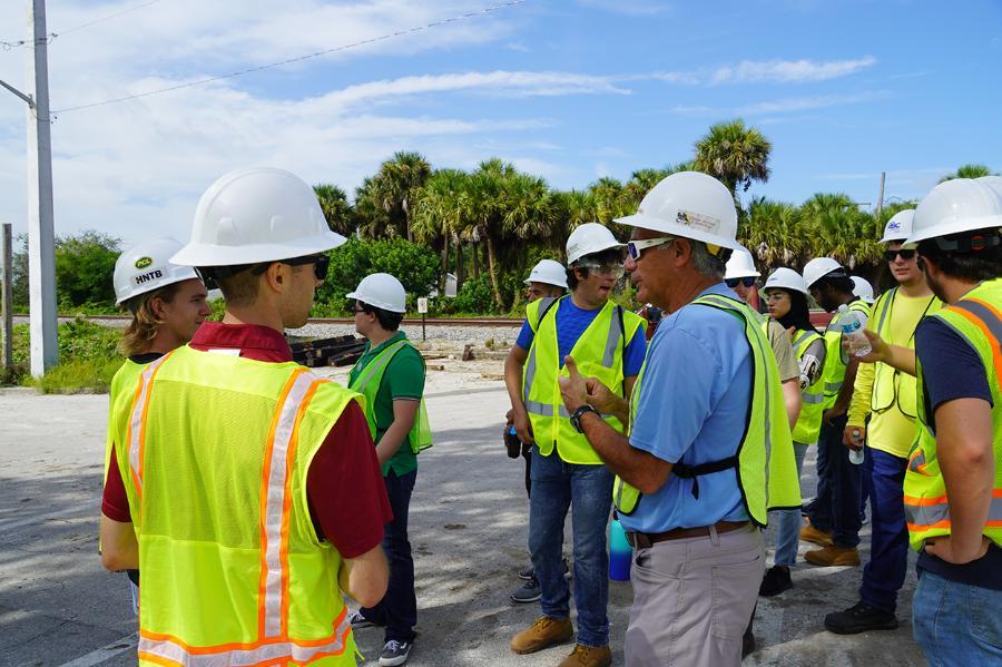 Photo of a professor lecturing outside with civil engineering students