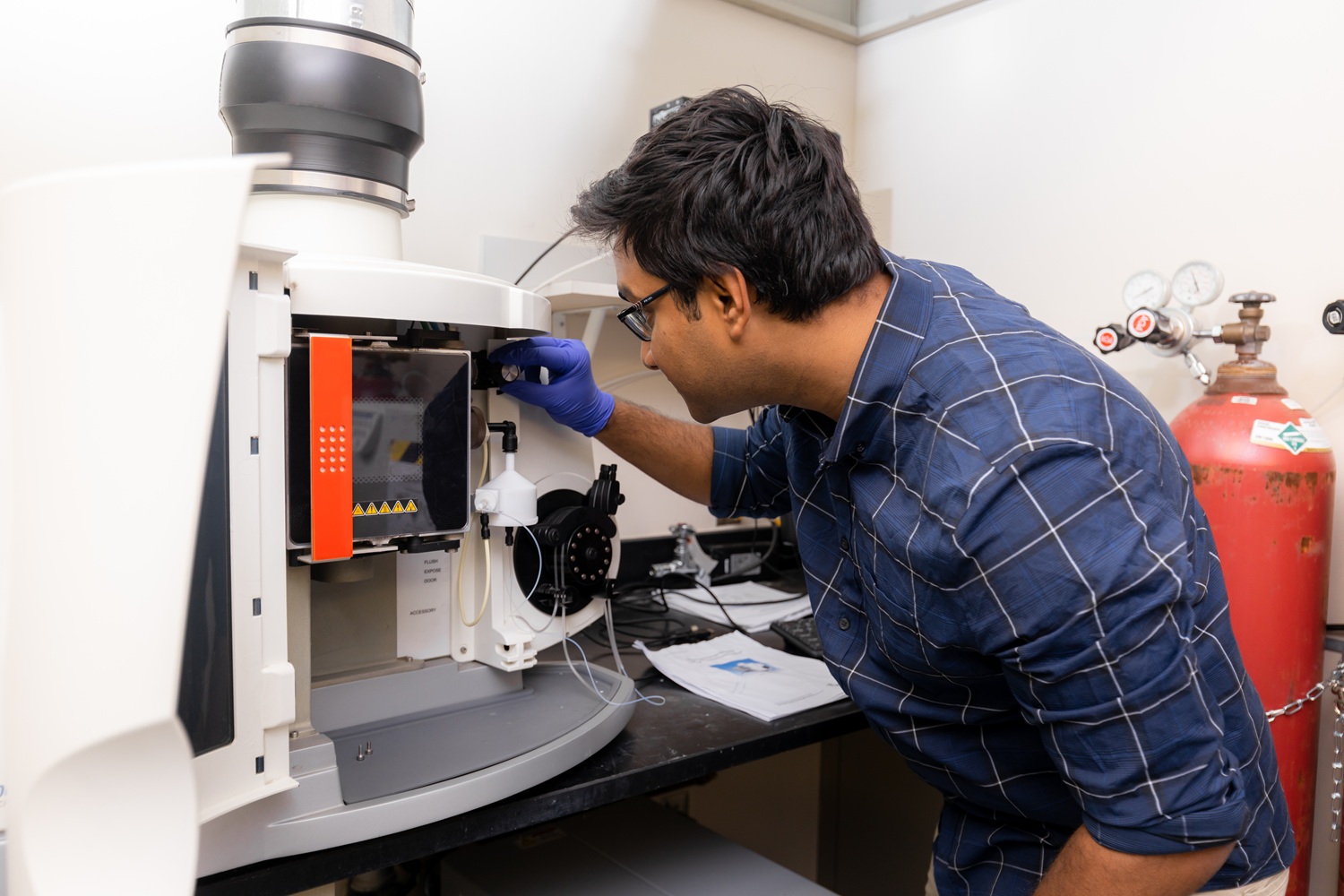 A chemical engineering graduate student using the Inductively Coupled Plasma Optical Emission Spectrometer (ICP-OES).