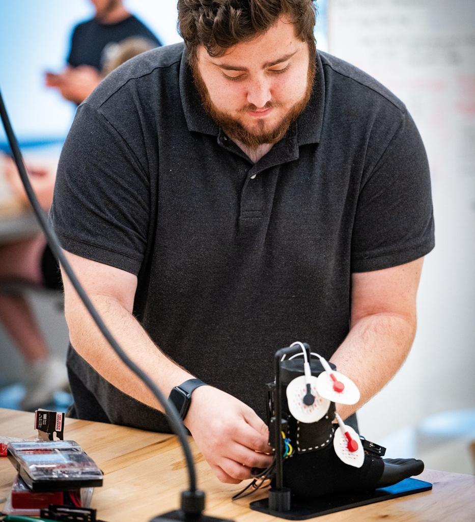 A student works with sensors on a model foot