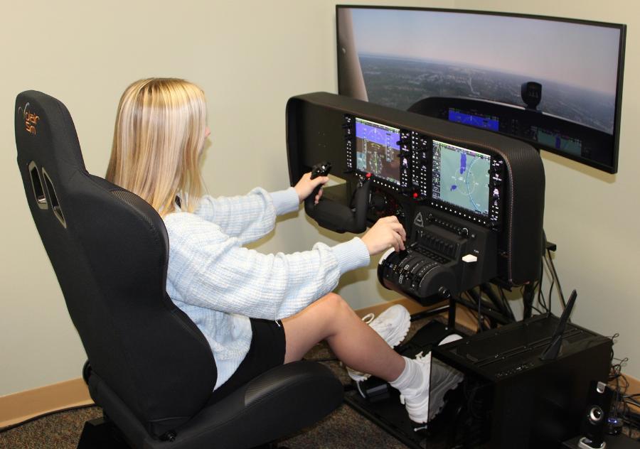 A student using a flight simulator device in research.