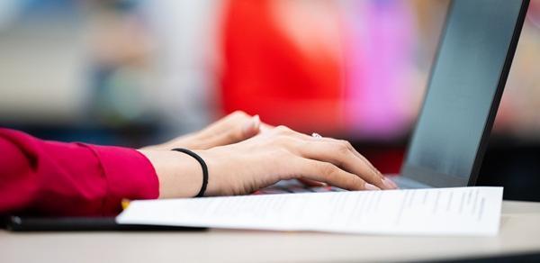 closeup of hands typing on laptop