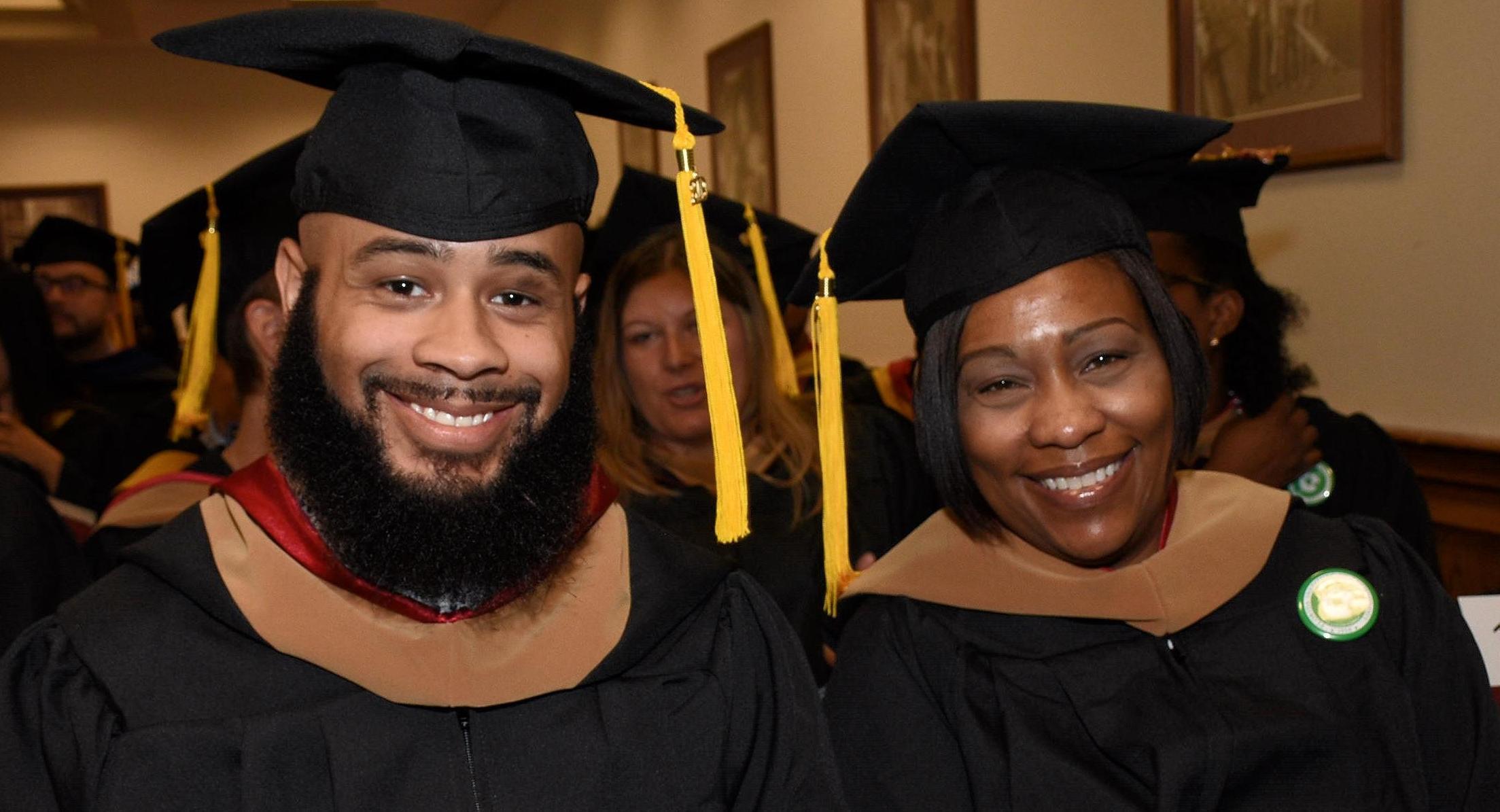 Two students about to graduate with their masters degrees