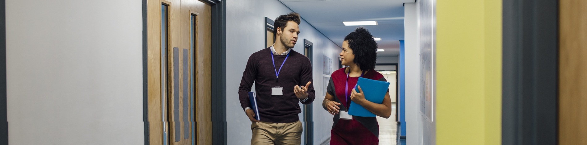 Two educators walking down a school hall