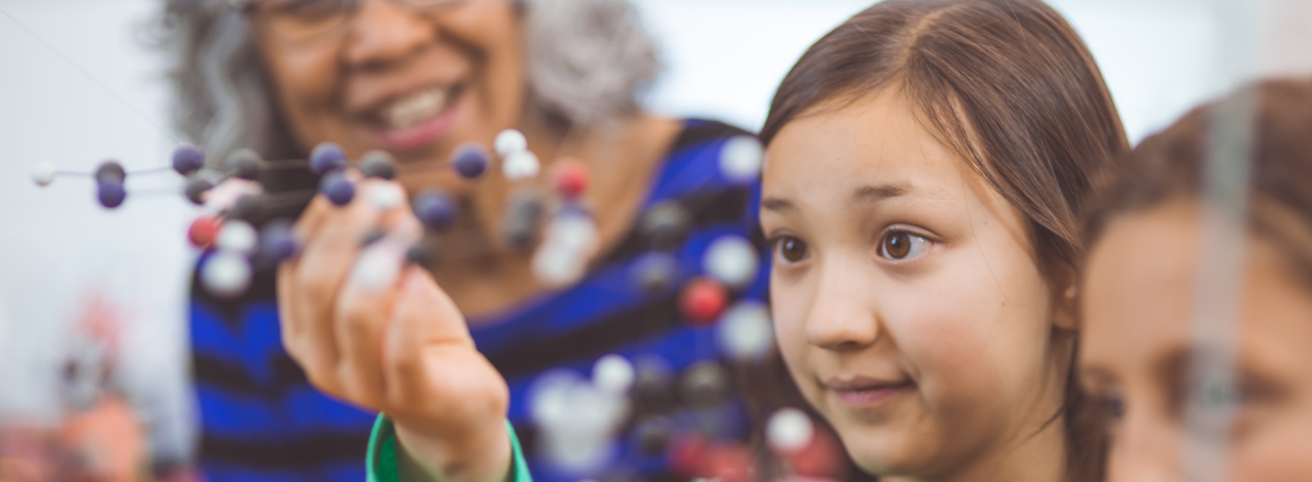 A teacher working with a student in a STEM classroom.