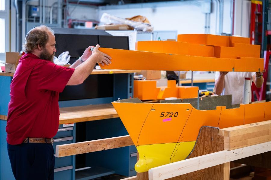 Dr. Travis Hunsucker working with a scale self-propelled model of a U.S. Navy research ship