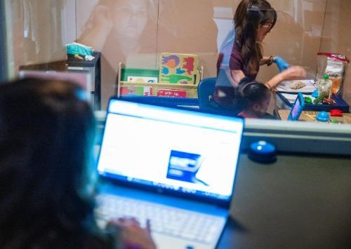An ABA practitioner working with a child being observed from an observation room.