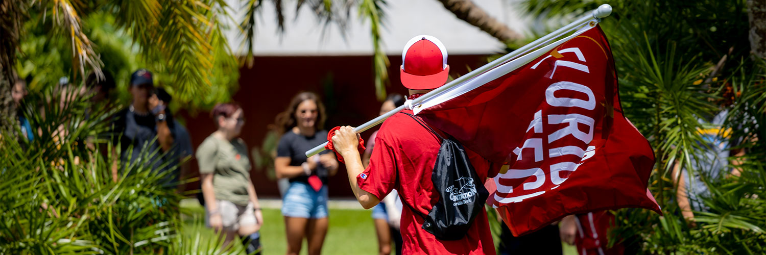 Student Holding Florida Tech Flag on College Colors Day