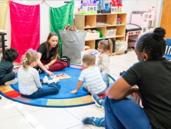 Two staff delivering ABA services to several children