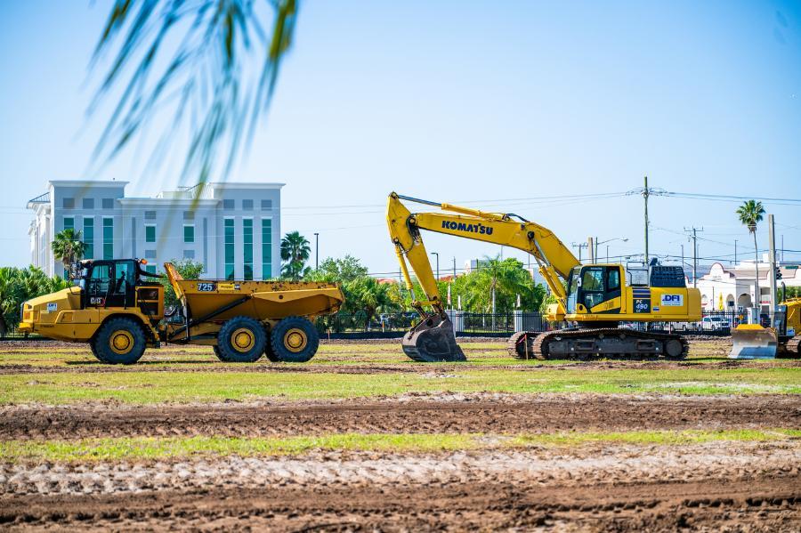 A pair of large construction vehicles poised and ready to break ground on the former intramural field.