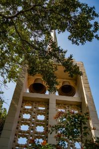 Looking up through a tree at the steeple and bells at the All Faiths Center
