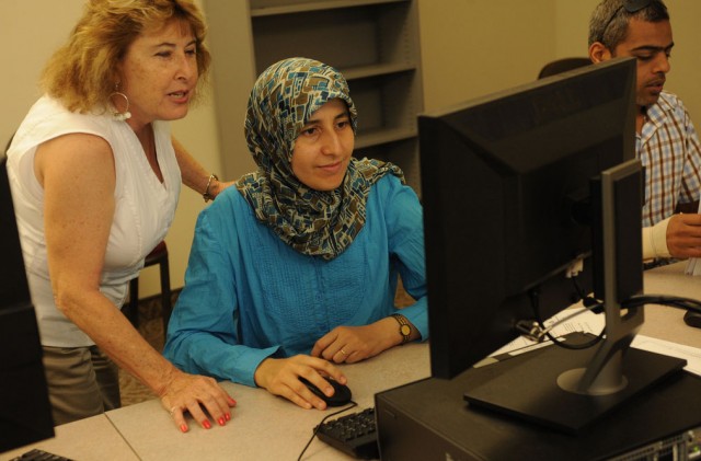 A professor helping a student at the computer