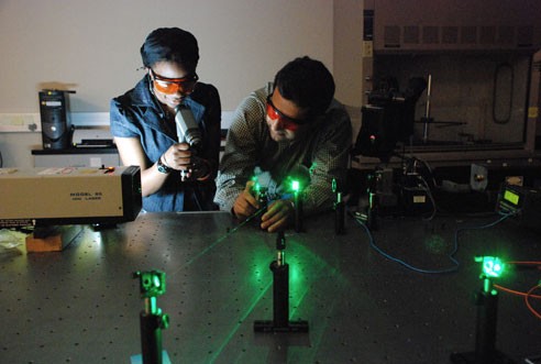 Two students working with a laser