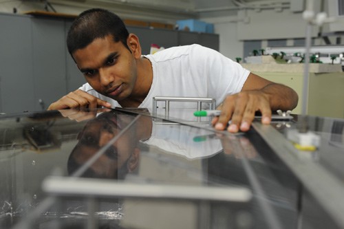 Student cutting steel with a machine