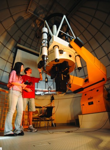 Two students looking through a telescope