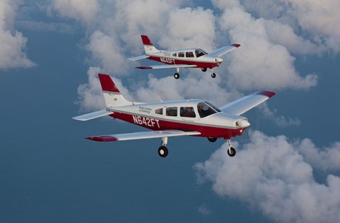 Two small planes flying in the sky