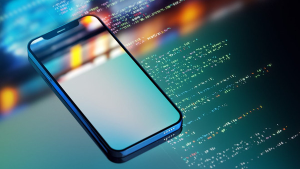 A cell phone resting on a background of computer code