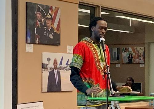 Male speaker at past event with images behind him.