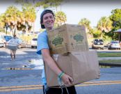 student carrying boxes