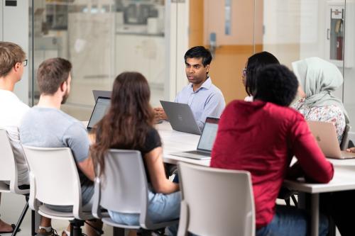 Graduate students meeting with a faculty member in a lab