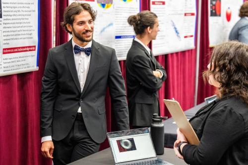 A student presents his research at the student design showcase.