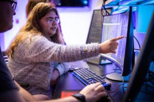 Students working together on a computer with lots of data displayed