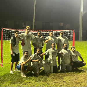 Students from the champion intramural soccer team smiling and posing in front of a goal.