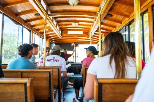 A group of prospective and current college students taking a ride on campus transit during a tour.