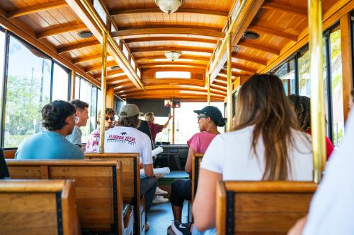 A group of prospective and current college students taking a ride on campus transit during a tour.